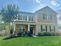 Charming two-story home featuring stone accents and a well-manicured lawn at 19455 Smith Cir, Cornelius, NC 28031