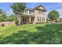 Charming two-story home with stone accents and well-manicured lawn on a sunny day at 19455 Smith Cir, Cornelius, NC 28031