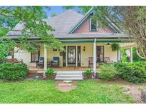 Charming home featuring a spacious front porch with swing and ample seating to enjoy the landscaped front yard at 200 W 14Th St, Salisbury, NC 28144