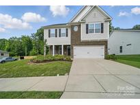 Charming two-story home featuring a brick and siding facade, landscaped front yard, and a two-car garage at 2034 Houle Ln, Charlotte, NC 28214