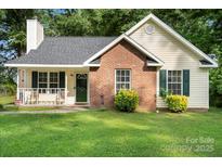 Charming one story home featuring a brick facade, covered front porch and well maintained lawn at 209 Mcfadden St, Rock Hill, SC 29730
