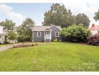 Charming home boasts beautiful landscaping, a well-maintained lawn, and a welcoming light blue front door at 2421 Morton St, Charlotte, NC 28208