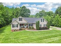 Charming single-story home with manicured lawn, mature trees, and inviting front porch at 320 Bluegill Ln, Statesville, NC 28625