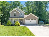 Charming two-story home with a well-manicured lawn, an attached two-car garage and mature trees at 3902 Mcgee Point Rd, Terrell, NC 28682