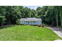 Charming single-story home with a manicured lawn, surrounded by lush trees and a welcoming front porch at 4007 Black Oak Rd, Hickory, NC 28602