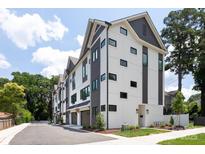 Modern townhome exterior with white and gray siding, black window frames, and attached garages at 4203 Walker Rd, Charlotte, NC 28211