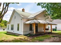 Charming home featuring a porch swing, awning, and well-maintained lawn at 505 S Eastway Dr, Troutman, NC 28166