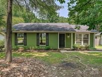 Charming single-story home featuring a black front door and lush green surroundings at 5811 Rock Hollow Dr, Charlotte, NC 28212