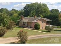 Charming brick home with a well-maintained lawn and mature landscaping creates a welcoming curb appeal at 6229 Mountain Grove Rd, Hickory, NC 28602