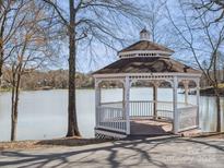 Picturesque white gazebo on the shore of a tranquil lake, perfect for relaxation and enjoying scenic views at 714 Deerbrook Ln, Tega Cay, SC 29708