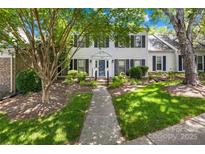 Charming townhouse with black shutters, a well-manicured lawn, and mature trees providing shade at 7528 Red Oak Ln, Charlotte, NC 28226