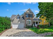 Charming two-story home with a stone facade, manicured lawn, and inviting front porch at 8109 Hawk Crest Ct, Charlotte, NC 28270