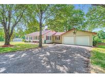 Charming single-story home with a red metal roof, an attached two-car garage, and a spacious front yard at 8255 Castor Rd, Salisbury, NC 28146