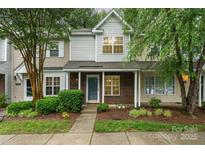 Charming townhome with a brick facade, manicured landscaping, and a welcoming covered front porch at 10223 Reindeer Way Ln, Charlotte, NC 28216