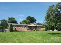 Charming single-story brick home with a large, well-maintained front yard and mature trees at 110 Heritage Dr, Kings Mountain, NC 28086