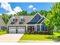 Charming home featuring a manicured lawn, lovely landscaping, and a convenient two-car garage at 129 Hawks Creek Pkwy, Fort Mill, SC 29708