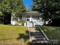 Charming home featuring a covered porch, brick chimney, and landscaped front yard at 208 S Ransom St, Gastonia, NC 28052