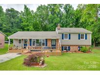 Charming split-level home with large front yard, brick accents, blue shutters and spacious deck for outdoor enjoyment at 2111 Parkdale Ave, Gastonia, NC 28052