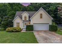Charming yellow home featuring an attached garage and a beautifully landscaped front yard at 270 Kilmer Ln, Mooresville, NC 28115