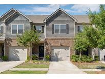 Charming townhome showcasing a brick and shake facade, complemented by a one-car garage and professionally landscaped front yard at 344 Kennebel Pl, Fort Mill, SC 29715