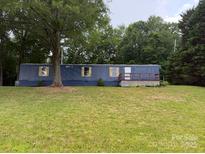 A manufactured home with a blue exterior and a grassy front yard at 41042 Dennis Rd, Albemarle, NC 28001