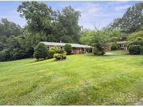 A charming one-story home featuring a well-manicured lawn and beautiful, mature trees at 46 Donna Dale Se Ave, Concord, NC 28025