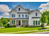 Beautiful two-story home featuring stone accents, a well-manicured lawn, and a welcoming front porch at 509 Abelia Ln, Fort Mill, SC 29708