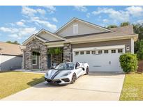 Charming home featuring stone accents, a two-car garage, and a well-maintained lawn at 6007 Eleanor Rigby Rd, Charlotte, NC 28278