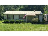 Quaint single-story home with a metal roof, complemented by tidy landscaping and a well-manicured lawn at 6544 Helens Way, Denver, NC 28037