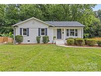 Charming white brick home with a manicured front yard and blue shutters at 7219 Brynhurst Dr, Charlotte, NC 28210