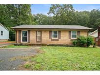 Traditional brick single-story home with dark shutters, inviting entrance, and a spacious front lawn at 924 Carrington Dr, Charlotte, NC 28214