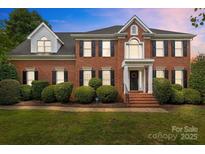 Beautiful brick home with a manicured lawn and mature landscaping for great curb appeal at 9717 Waterton Ct, Huntersville, NC 28078