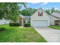 Charming single-Gathering home with a well-manicured lawn, mature trees, and a two-car garage at 11021 Travis Gulch Dr, Charlotte, NC 28277