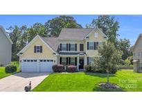 Charming two-story home with a well-manicured lawn, a two-car garage, and a welcoming front porch at 11618 Macallano Dr, Charlotte, NC 28215