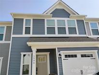 Charming two-story townhome with blue siding, white trim, and an attached one car garage at 1598 Respect St, Concord, NC 28027