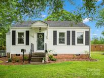 Charming single-story home featuring a welcoming front porch, black shutters, and well-maintained landscaping at 206 Charlotte St, York, SC 29745