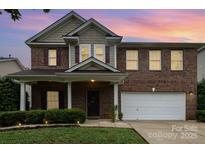 Charming two-story brick home with a manicured front yard and attached two-car garage at 237 Lylic Woods Dr, Fort Mill, SC 29715