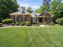 Charming brick home boasts manicured lawn and lush landscaping, creating a welcoming curb appeal at 2616 Carmarthen Ct, Matthews, NC 28104