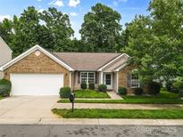 Charming brick and vinyl ranch home with manicured lawn, and two-car garage at 3008 Cornflower Ln, Indian Trail, NC 28079