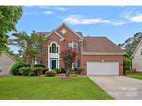 Charming two-story brick home with a well-manicured front lawn and attached two-car garage at 3830 Waters Reach Ln, Indian Trail, NC 28079