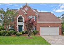 Two-story brick home featuring a well-maintained lawn and a two-car garage at 3830 Waters Reach Ln, Indian Trail, NC 28079