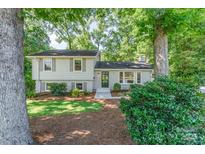 Charming home featuring a manicured lawn, mature trees, and inviting front entrance at 4014 Sulkirk Rd, Charlotte, NC 28210
