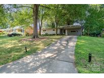 Charming single-story home with mature trees, a long driveway, and a carport at 5742 Murrayhill Rd, Charlotte, NC 28210