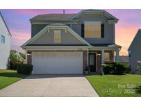 Charming two-story home featuring a stone facade and attached garage with a well-manicured lawn at 6156 Kilchurn Dr, Fort Mill, SC 29707