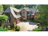 Beautiful brick and stone home featuring a circular driveway, professional landscaping, and a three car garage at 617 Beauhaven Ln, Waxhaw, NC 28173