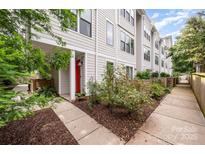 Charming townhome exterior with red door, sidewalk, and well-maintained landscaping at 1207 E 36Th St, Charlotte, NC 28205