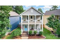 Charming two-story home with double front porches, bright blue door, and manicured landscaping at 12304 Huntersville Concord Rd, Huntersville, NC 28078