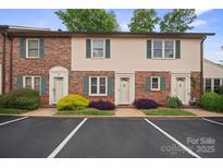 Charming townhome exterior featuring brick and vinyl siding, green shutters, and well-maintained landscaping at 1330 5Th Ne St, Hickory, NC 28601