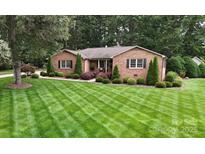 Charming brick home featuring a beautifully manicured lawn and lush landscaping at 1695 Arden Dr, Lincolnton, NC 28092