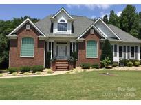 Charming brick home boasts meticulous landscaping and a welcoming front entrance, perfect for curb appeal at 1842 Caroline Way, Fort Mill, SC 29715